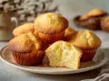 En tallrik med fluffiga muffins, perfekt för ett enkelt muffins recept. En muffin är delad och visar en mjuk insida.