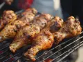 Grillade kycklingklubbor med kryddig jerk chicken-marinad som ryker över glöden.