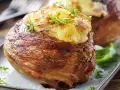 En härlig bakad potatis insvept i knaperstekt bacon, toppad med ost och örter. En riktig delikatess!