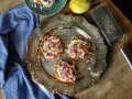 Tre potatisbullar med räkor, rödlök och dill på en silverbricka. Ett recept på potatisbullar som ser utsökt ut!