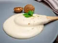 Krämig bechamelsås på en tallrik med muskotnötter och persilja. Ett perfekt bechamelsås recept för alla tillfällen.