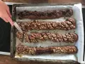 Chokladsnittar recept: Nybakade chokladkakor med nötter och chokladbitar skärs upp på en plåt.