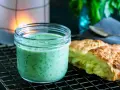 En burk med krämig, grön dressing, perfekt för ett grönt gudinnedressing recept. Bredvid ligger nybakade scones.