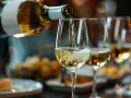 Vitt vin hälls upp i ett glas, perfekt för matlagning eller en festlig middag.