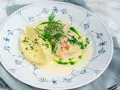 En vacker tallrik med torskrygg recept, serverad med krämigt potatismos och en grön dillolja.