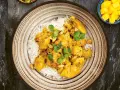 En krämig kycklingcurry med ris, toppad med koriander och jordnötter. En riktig curry nam nam!