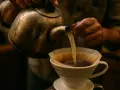 Här hälls varmt vatten över kaffepulver i ett filter. Ett perfekt iskaffe recept börjar med omsorgsfull bryggning.