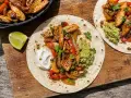 Två läckra fajitas med kyckling, paprika, lök, guacamole och gräddfil. Ett perfekt fajitas recept för en härlig middag.