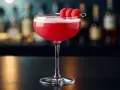 En rosa drink, en Clover Club, med hallon på en cocktailpinne.