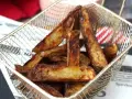 Krispiga pommes frites i airfryer, gyllene och redo att serveras i en metallkorg.