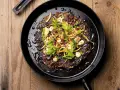 En mörk, krispig pannkaka med kirskål, toppad med färska örter, granatäppelkärnor och en krämig dressing. Ett spännande kirskål recept!