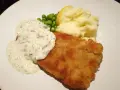 En gyllene panerad fisk med krämig sås, ärtor och potatismos. En klassisk och god måltid.