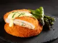Krispig cordon bleu med krämig fyllning och hollandaisesås, serverad med sparris.
