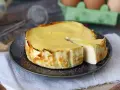 En krämig ricotta cheesecake, perfekt för ett enkelt ricotta recept. En bit är uppskuren och visar den lena insidan.