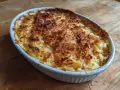 En gyllene Janssons frestelse i en vit ugnsform, redo att serveras. Ett klassiskt recept som doftar jul.