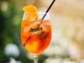 Ett glas med en orange aperol drink utan prosecco, is och en apelsinskiva.