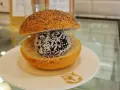 En bulle med bulle: en chokladboll med kokosflingor inuti en delad bulle med vallmofrön.