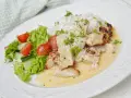 En krämig kycklinggryta med bacon, serverad med ris och en fräsch sallad.