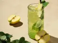 En uppfriskande p2 drink med äpple, lime och mynta. Två halvor av ett grönt äpple ligger bredvid glaset.