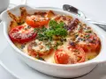 Gratinerade tomater med ost och örter, perfekt tillbehör till ett falukorv recept.