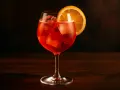En Campari Spritz med is och en apelsinskiva, perfekt för en solig dag.