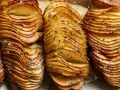Krispiga hasselbackspotatisar, perfekt för ett enkelt hasselbackspotatis recept. Garnerade med örter och flingsalt.