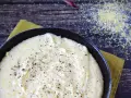 Krämig polenta i en gjutjärnspanna, strödd med peppar. Perfekt för ett enkelt polenta recept.