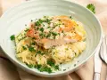 En krämig portion chicken alfredo med tagliatelle, toppad med grillad kyckling, parmesan och färsk persilja.