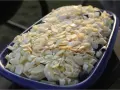 En blå form fylld med frukt och toppad med mandelspån. Perfekt för ett Gino recept.
