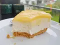 En krämig bit citron cheesecake med krispig botten, perfekt för en fika.