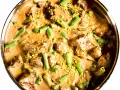 En krämig biff stroganoff med möra köttbitar och gröna bönor, toppad med gul strössel.