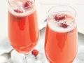 Två glas med ett rosa drink med bubbel och hallon. Perfekt för en festlig stund.