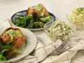 Två bakade potatisar med en krämig bakad potatis fyllning, serverade med en fräsch sallad och två skålar med olika röror.