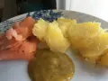 En tallrik med gravad lax, kokt potatis och en klick gravlaxsås. Perfekt för ett snabbt och gott recept.