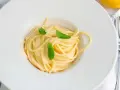 En krämig pasta limone, serverad i en vit skål med färska myntablad.