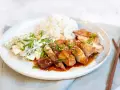 En tallrik med saftig chicken teriyaki, ris och en krämig gurksallad. Garnerad med salladslök och sesamfrön.