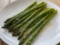 En tallrik med nykokt sparris, lätt oljad och strödd med flingsalt och peppar. Perfekt för att koka sparris till en enkel och god rätt.