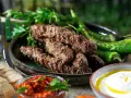 Grillade cevapcici med gröna paprikor, persilja, pitabröd och en röd röra. Ett perfekt cevapcici recept för sommaren.