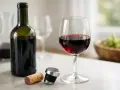 En flaska rött vin, ett glas fyllt med vin, en kork och en vinpropp. Frågan är, kan vin bli gammalt?