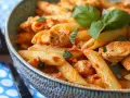 En skål med krämig pasta med kyckling och basilika. En härlig pasta med creme fraiche som ser utsökt ut.