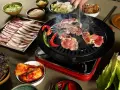 En härlig **korean bbq**-upplevelse med saftigt kött som grillas, serverat med kimchi, vitlök och färska grönsaker.