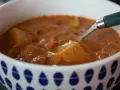 En skål med mustig cowboy soppa med potatisbitar och en sked.