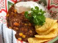 En skål med chili con carne, ris, gräddfil och tortillachips. Perfekt vin till chili con carne!