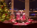 Ett dukat bord med julgran och tända ljus, redo för ett härligt vin till julbordet.