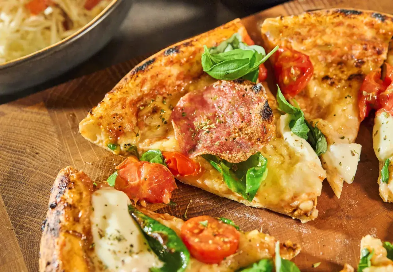 Krispiga pizzakanter med salami, tomater och basilika. Ett perfekt pizza recept för en mysig kväll.