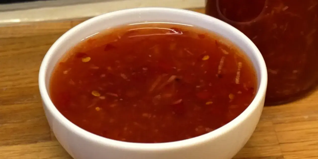 En skål med söt chili sås, redo att förhöja smaken på din favoritmat.