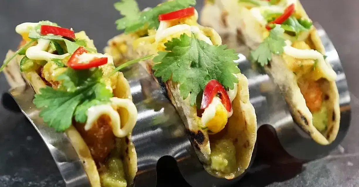 Tre läckra asiatiska tacos med koriander, chili och majs i en taco-hållare.
