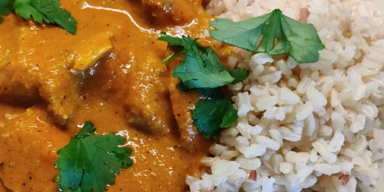 En krämig kycklingrätt med ris, perfekt för ett snabbt tikka masala recept. Garnerad med färsk koriander.