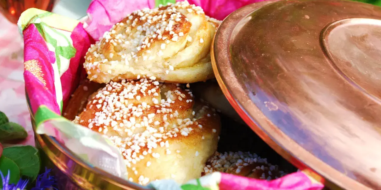 Nybakade vaniljbullar med pärlsocker i en fin burk, redo att avnjutas. Ett perfekt recept för fika.