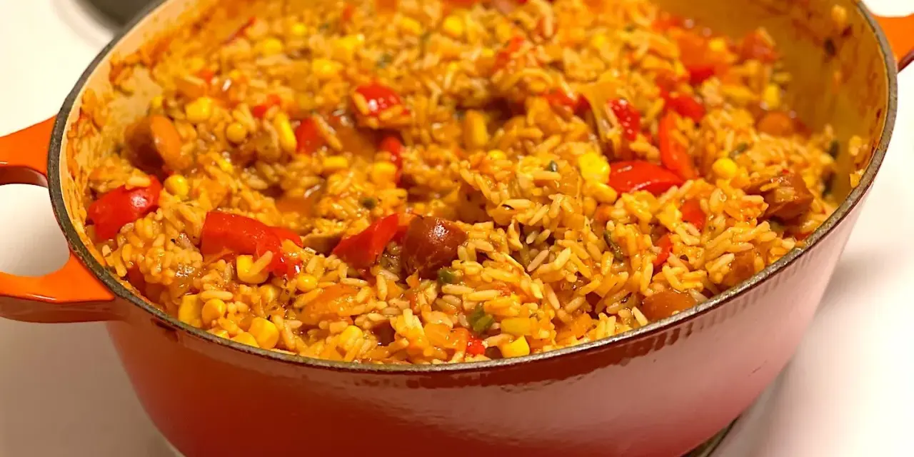 En orange gryta fylld med en smakrik jambalaya, full av ris, majs, paprika och korv. Ett perfekt recept för en mysig middag.